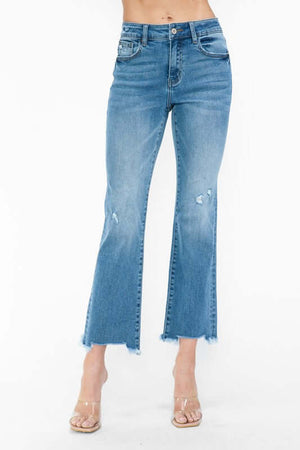 Trendy mid rise crop jeans with raw hem and distressed details, paired with stylish clear heels. Perfect for a casual chic look!