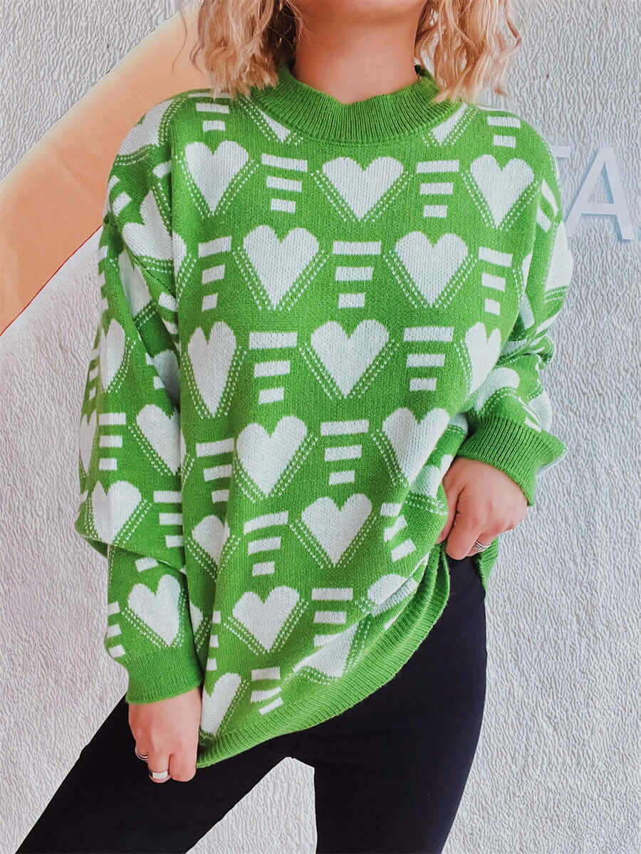 Woman wearing Bella Road Heart Contrast Long Sleeve Dropped Shoulder Sweater in green with white heart pattern.