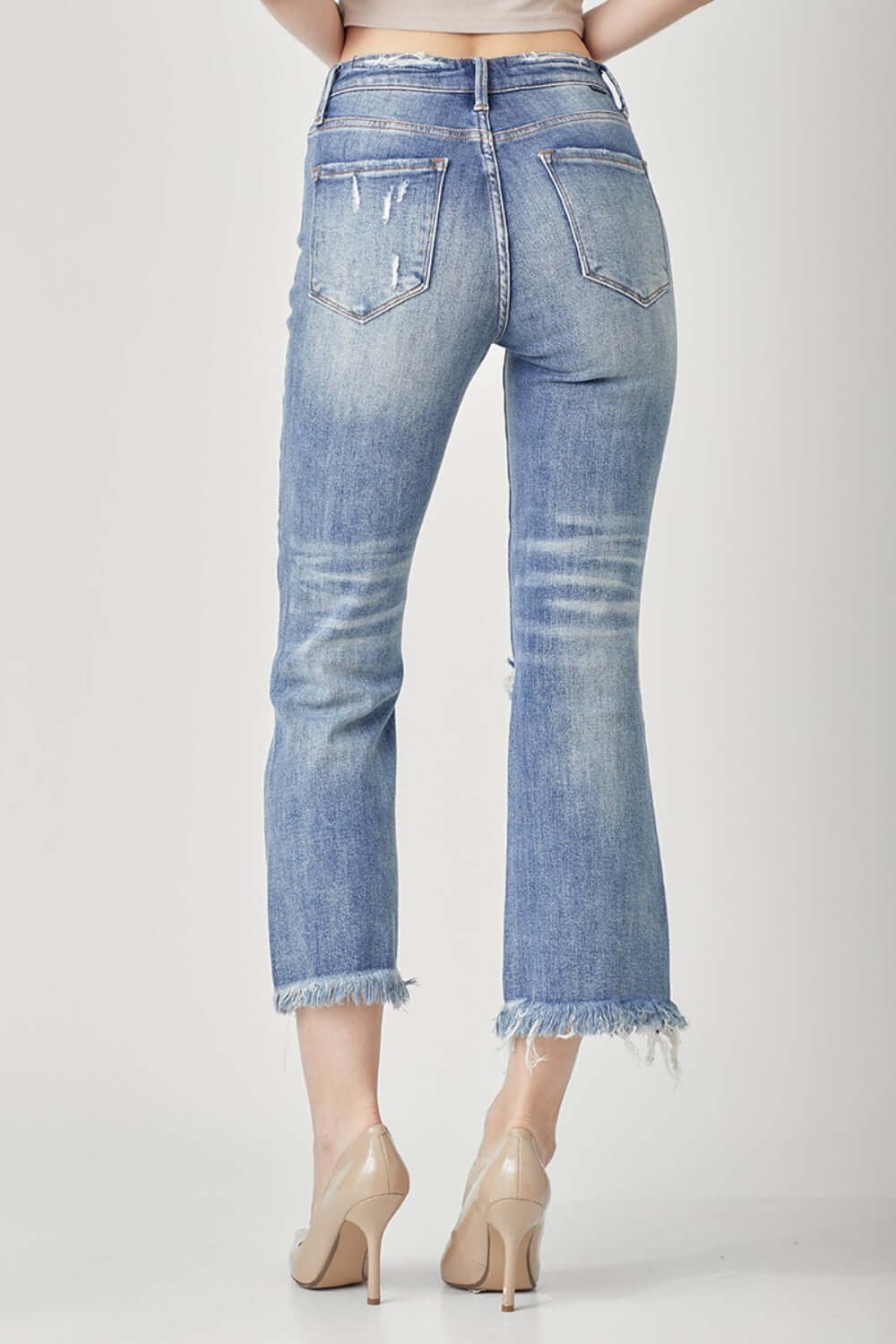 High Waist Distressed Cropped Bootcut Jeans in blue denim, showcasing back view with edgy details and modern cropped hem. Risen Jeans style.