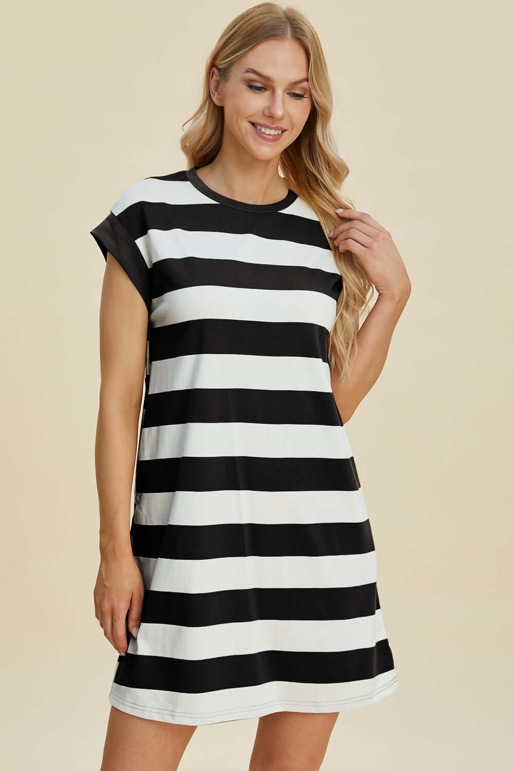 Woman wearing Basic Bae Full Size Striped Round Neck Cap Sleeve Mini Dress in black and white stripes, looking stylish and comfortable