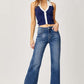 High Rise Frayed Hem Wide Leg Jeans with a flattering fit and retro flair, worn by a model in a navy top and white heels.