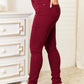 Woman modeling red YMI skinny jeans with pockets, showcasing the flexible and contouring fit that accentuates curves and offers comfort.