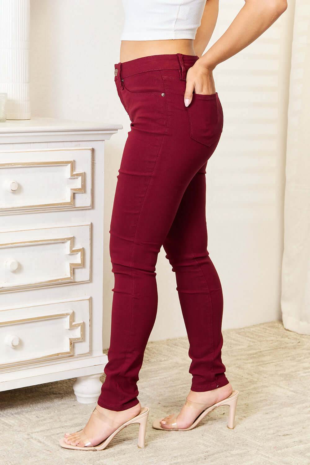 Woman modeling red YMI skinny jeans with pockets, showcasing the flexible and contouring fit that accentuates curves and offers comfort.