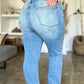 Woman wearing Judy Blue distressed straight jeans with patch pockets, showcasing the back view and light wash detailing.