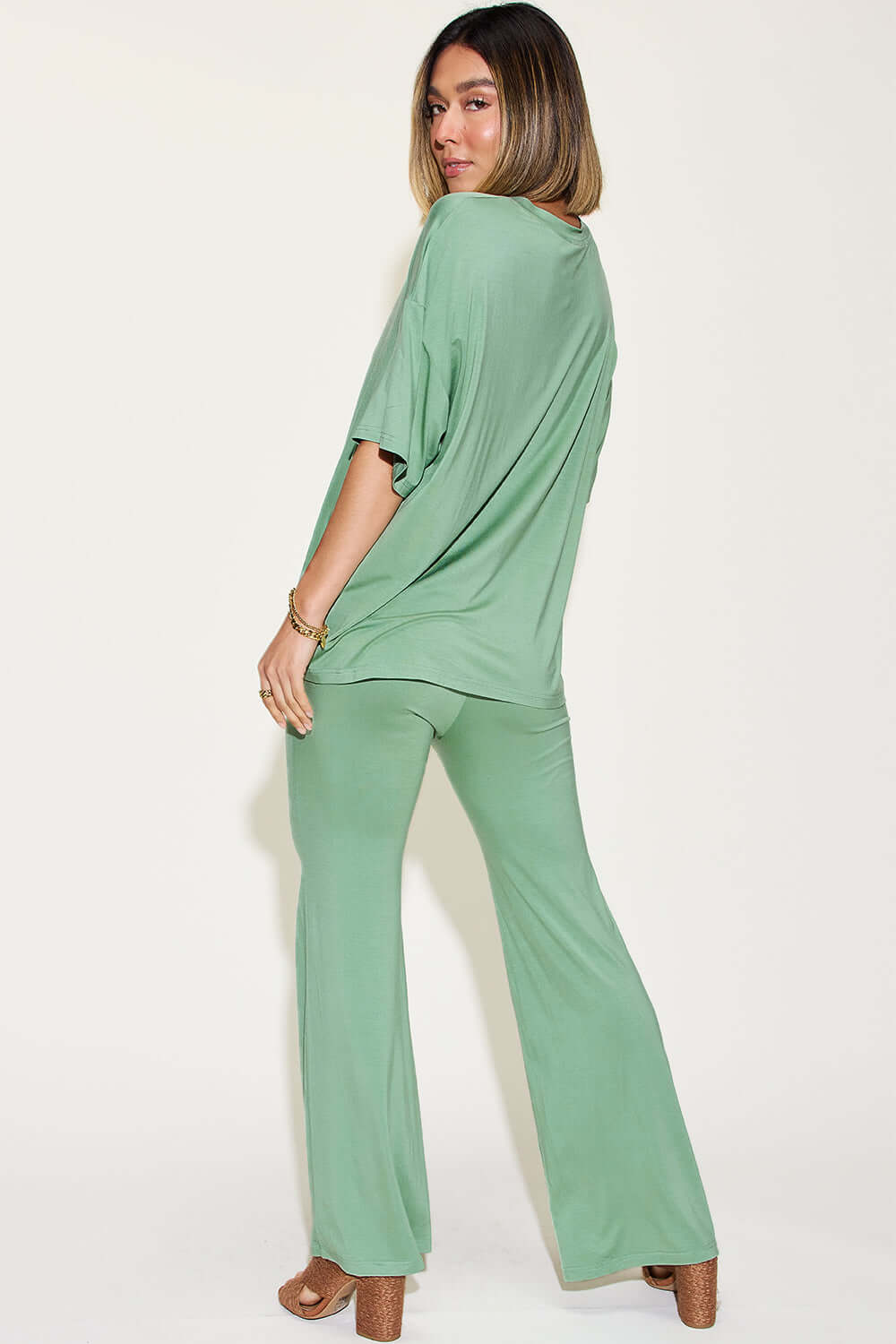 Woman wearing a green Bamboo Drop Shoulder T-Shirt and Flare Pants Set, featuring a basic style with a relaxed fit and stretchy bamboo fiber fabric.