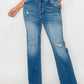 Raw hem distressed mid-rise straight jeans styled with a basic white top and sandals, showcasing trendy casual fashion.