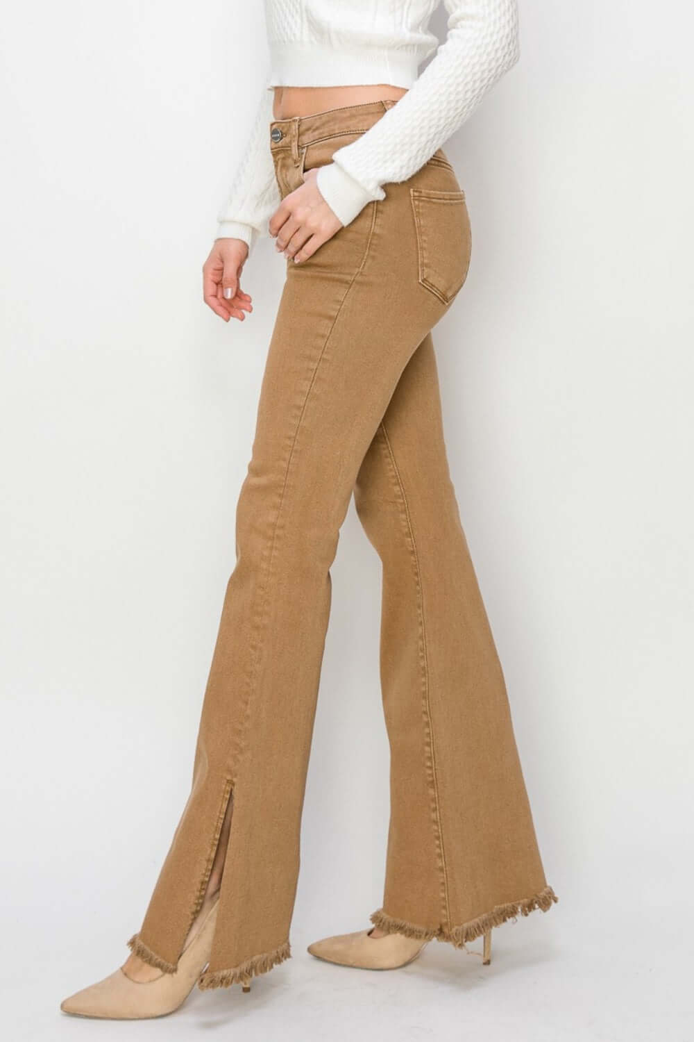 Woman wearing Bailey High Waist Side Slit Flare Jeans in brown with a white sweater, highlighting the side slit and flare design. Risen Jeans.