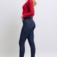 Woman wearing Judy Blue skinny jeans with heart-shaped back pockets, styled with a red top and heels, showcasing a chic silhouette.