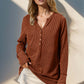 Woman wearing Double Take Full Size Notched Thumbhole Long Sleeve T-Shirt in brown, featuring buttoned detail and notched neckline.