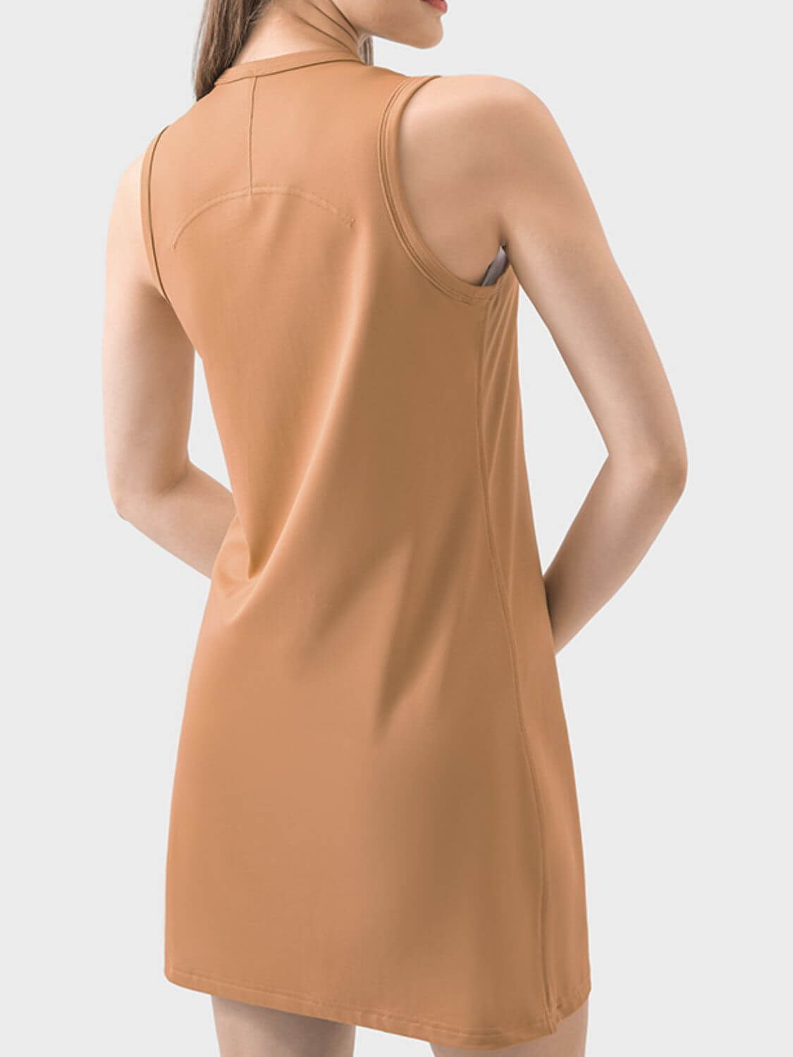 Model showcasing the back of the Millennia Round Neck Sleeveless Active Dress in a stylish tan color.