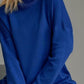 Cozy blue turtleneck sweater with side slits and dropped shoulders for a relaxed fit, perfect for stylish warmth.