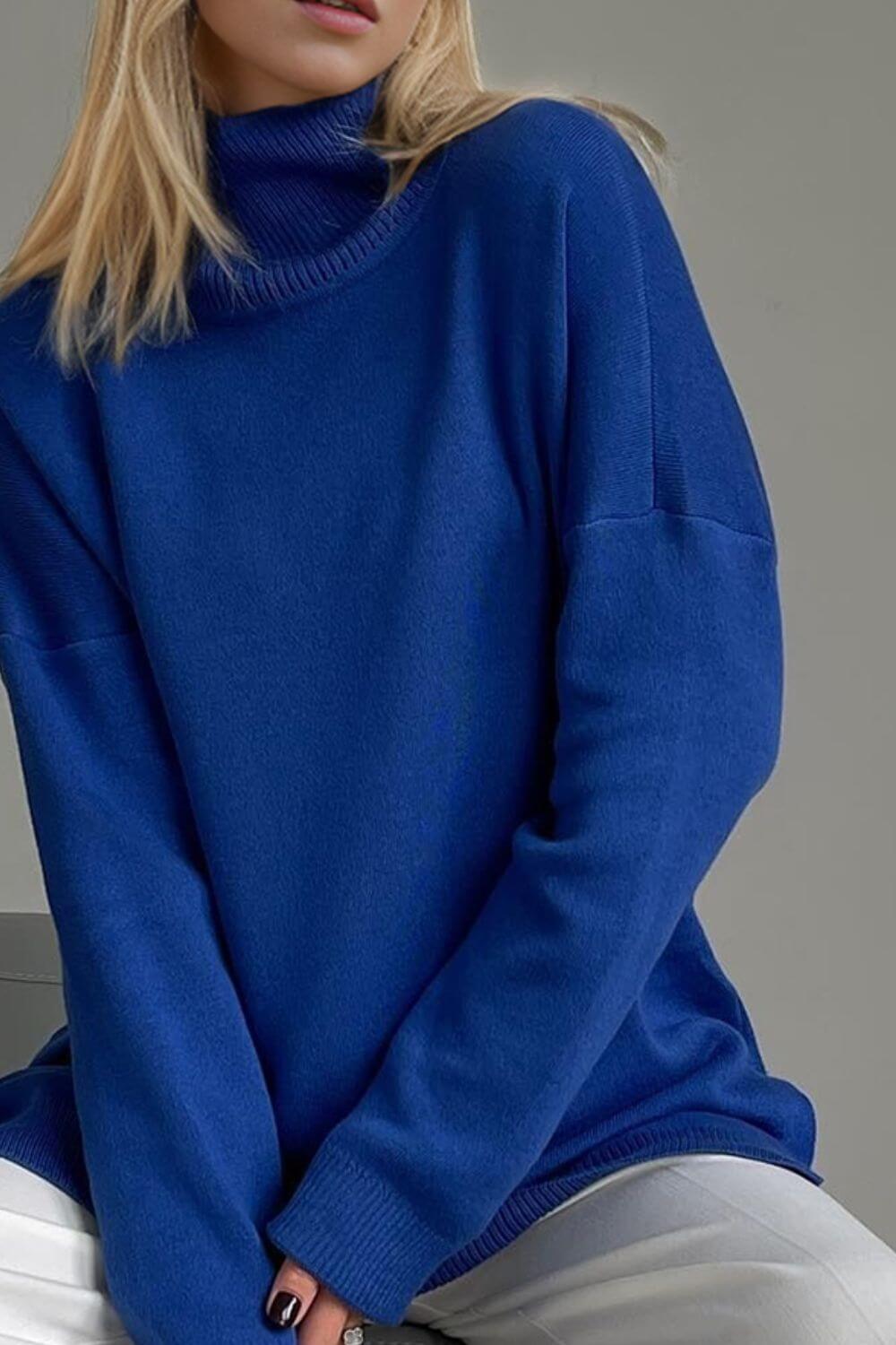 Cozy blue turtleneck sweater with side slits and dropped shoulders for a relaxed fit, perfect for stylish warmth.