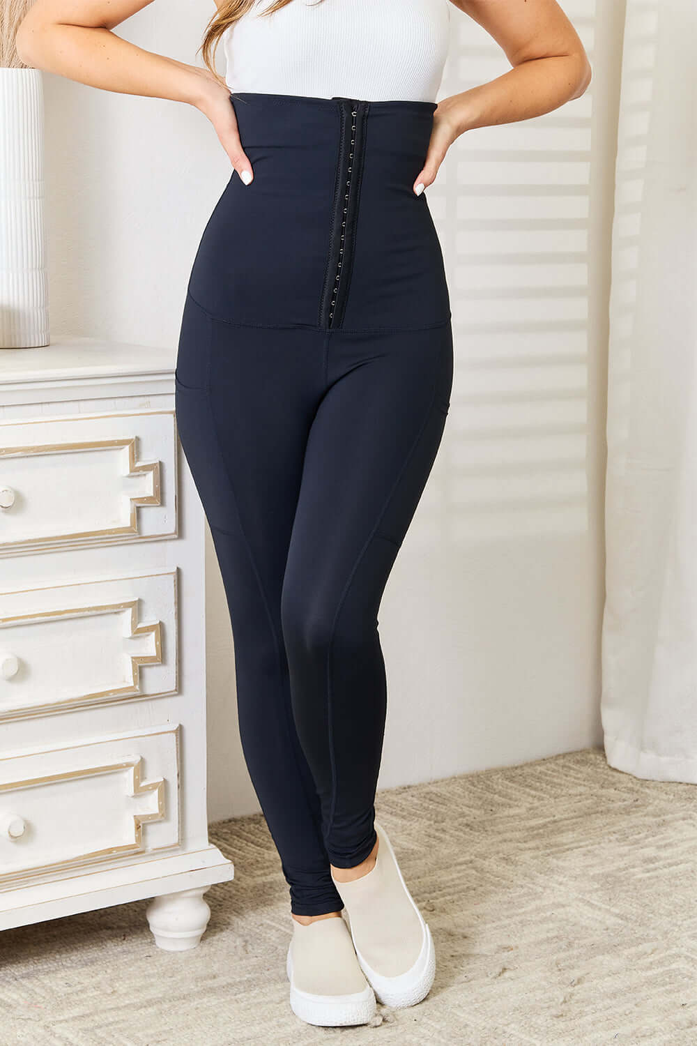 Woman wearing Heimish Full Size Waist Trainer Corset Leggings in a sleek black design, showcasing the extra high rise for a flattering hourglass silhouette