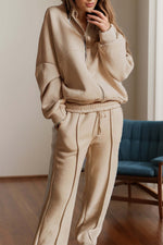 Woman wearing Bella Road Zip Up Long Sleeve Top and Pants Set in beige standing in a room.