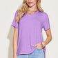 Woman wearing Bamboo V-Neck High-Low T-Shirt in lavender, basic style, slightly stretchy, made of bamboo and spandex, with light wash jeans.