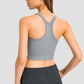 Stylish woman showcasing the Millennia Racerback Sports Bra from the back, featuring a sleek design and comfortable fit.