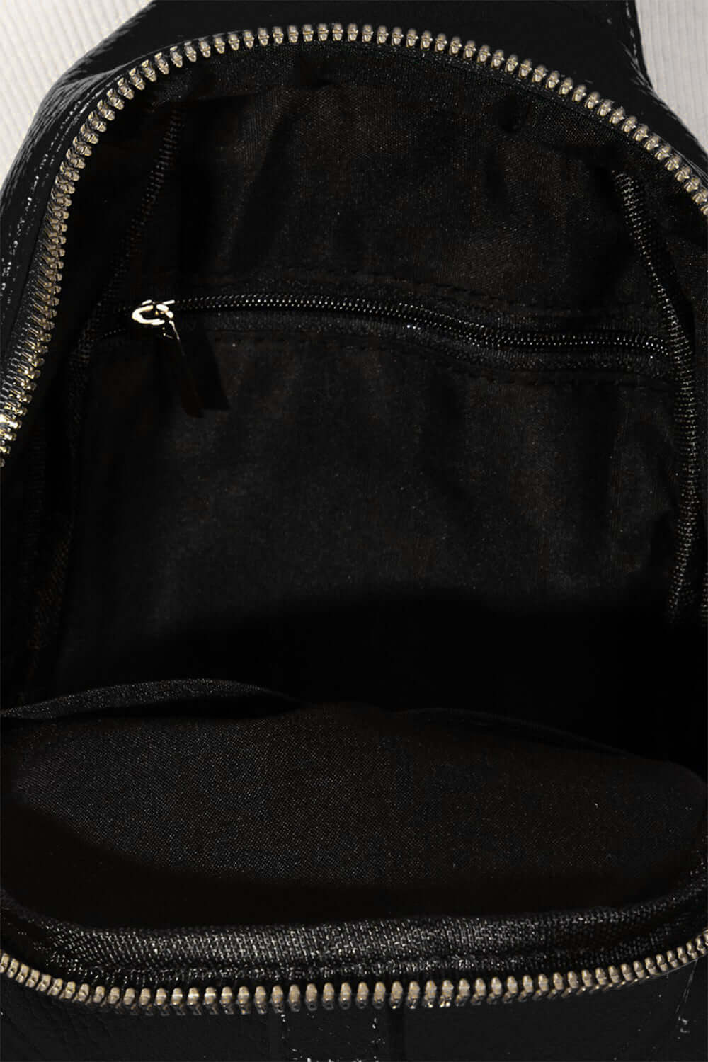 Inside view of Fame Single Strap Faux Leather Sling Bag, showcasing spacious compartments and a sleek black lining.