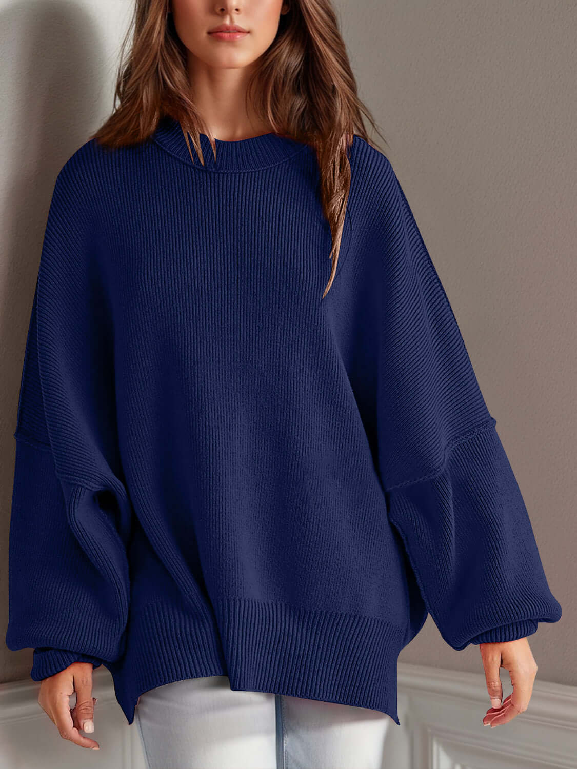 Double Take Side Slit Round Neck Long Sleeve Sweater in navy blue worn by model. Cozy fit, playful side slit design, made with cotton-polyester blend.