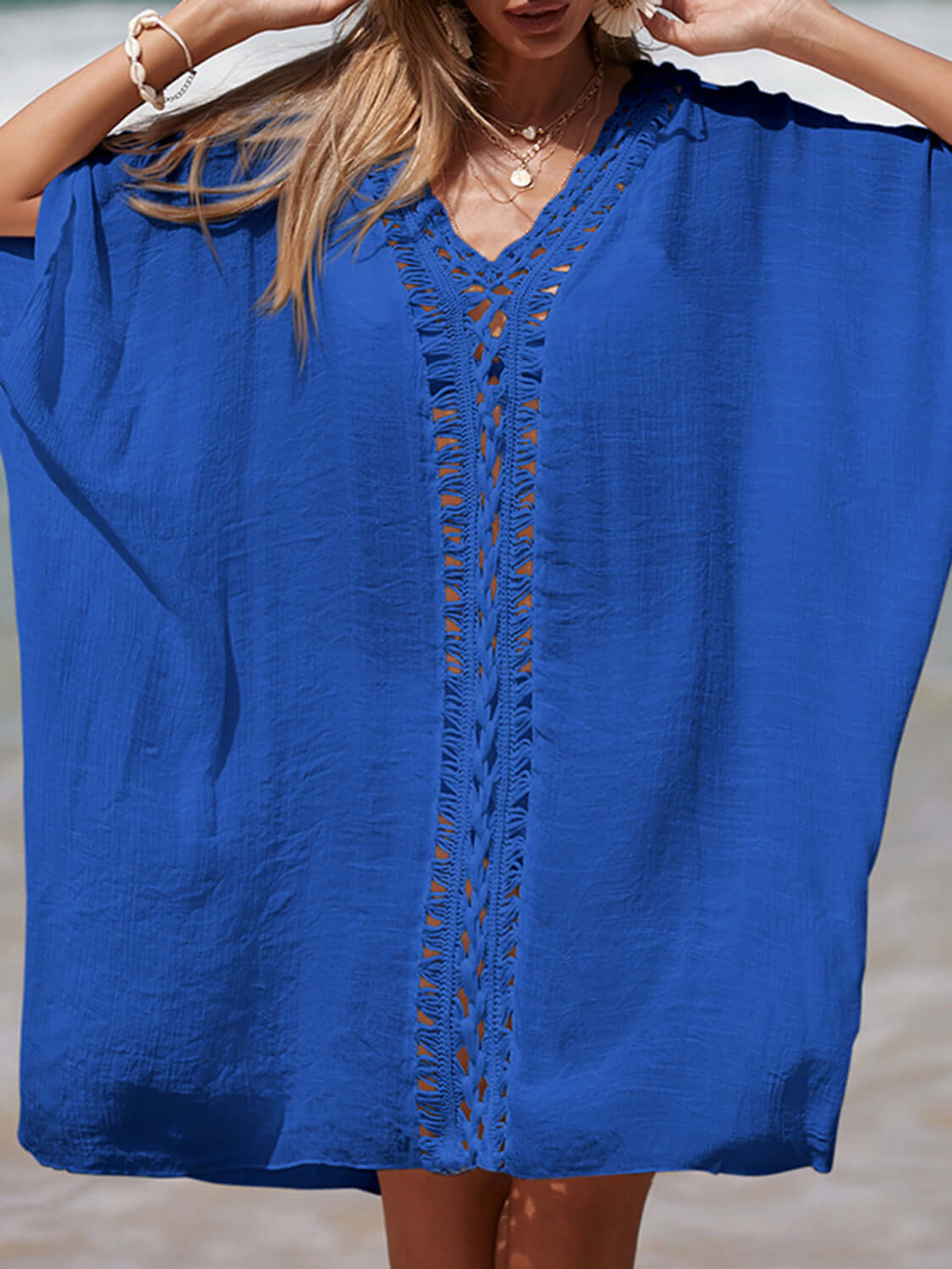 Woman wearing a blue Cutout V-Neck Three-Quarter Sleeve Cover Up on a beach.