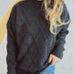 Bella Road diamond pattern round neck long sleeve sweater in black worn with blue jeans