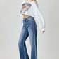 Woman wearing High Waist Wide Leg Jeans by Risen Jeans, paired with a white crop top and heels, showcasing a trendy and flattering outfit.