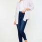 Woman wearing High Rise Frayed Ankle Skinny Jeans with a white shirt and beige shoes