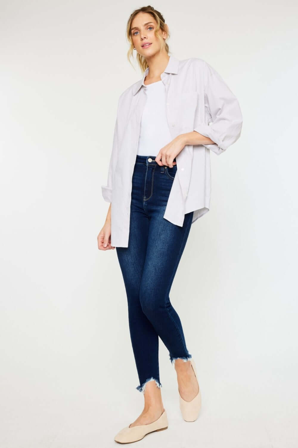 Woman wearing High Rise Frayed Ankle Skinny Jeans with a white shirt and beige shoes