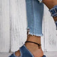 Model wearing Bella Road Raw Hem Wedge Buckle Sandals in denim paired with distressed jeans.