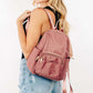 Stylish woman with medium pink nylon backpack featuring multiple pockets, perfect for daily adventures and travel.