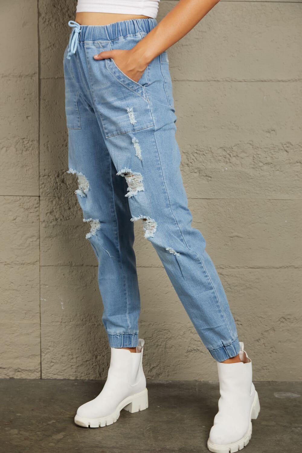 Baeful Distressed Denim Pocketed Joggers in blue, featuring fringe details, multiple pockets, and a casual, comfortable fit perfect for streetwear.