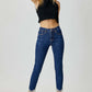 Woman wearing RISEN Full Size Embellished Mid Rise Crop Skinny Jeans paired with a black crop top