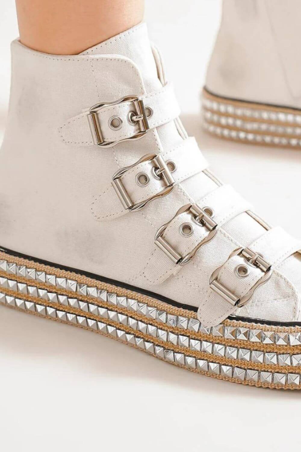 Edgy white platform sneakers with multi-buckle straps and studded detailing for a trendy, rock 'n' roll vibe.