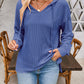 Woman wearing blue drawstring dropped shoulder long sleeve hoodie styled with jeans.