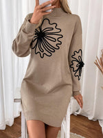 Woman wearing Perfee Flower Mock Neck Long Sleeve Sweater Dress with unique floral design, standing in cozy room.