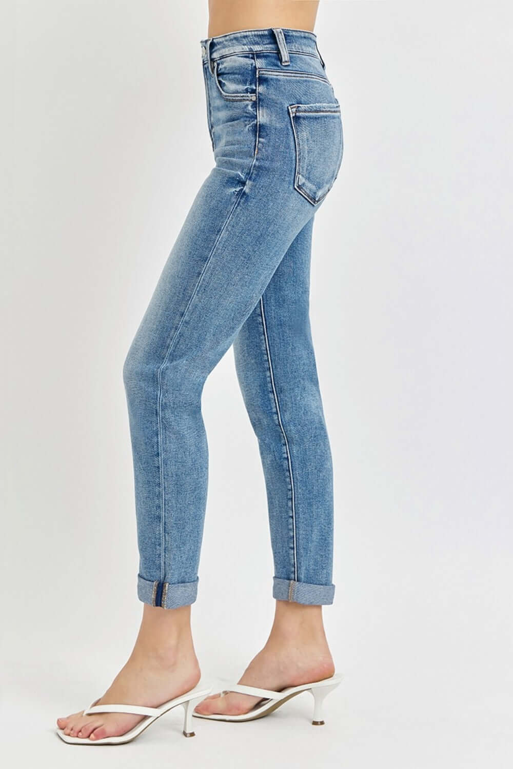 Woman wearing Risen Jeans High Rise Cropped Roll Up Jeans with high waistband, cropped length, and stylish rolled-up cuffs in quality denim.