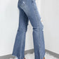 Distressed raw hem bootcut jeans with slightly stretchy material, featuring frayed edges. Styled with wedge sandals.