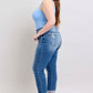 Model in blue tank top wearing Judy Blue button fly distressed plus size jeans with pockets, showcasing stylish fit.