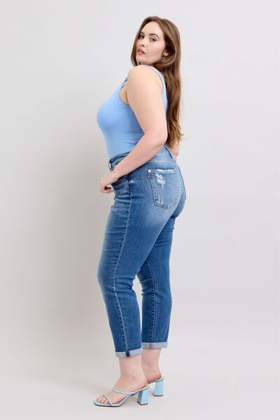 Model in blue tank top wearing Judy Blue button fly distressed plus size jeans with pockets, showcasing stylish fit.