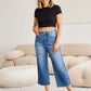 Woman wearing Judy Blue braid side detail wide leg jeans with a black crop top, showcasing trendy side braid detailing.