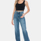 Stylish woman wearing Judy Blue Full Size Tummy Control Cut Raw Hem Straight Jeans with high-waist design and trendy raw hem.