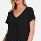 Woman wearing a trendy V-neck short sleeve crop t-shirt in black with jeans, showcasing a stylish and casual fashion look.