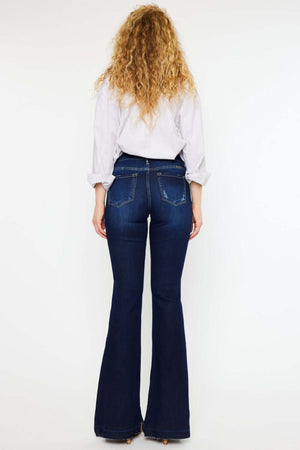 Woman wearing Kancan mid-rise slim flare jeans in dark stonewash, showcasing a stylish and flattering fit from the back.