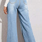 Back view of model wearing high waist wide leg jeans in light blue denim with no stretch, featuring back pockets and basic style.