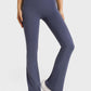 Woman wearing navy Millennia Elastic Waist Flare Yoga Pants, showcasing comfort and style for workouts.