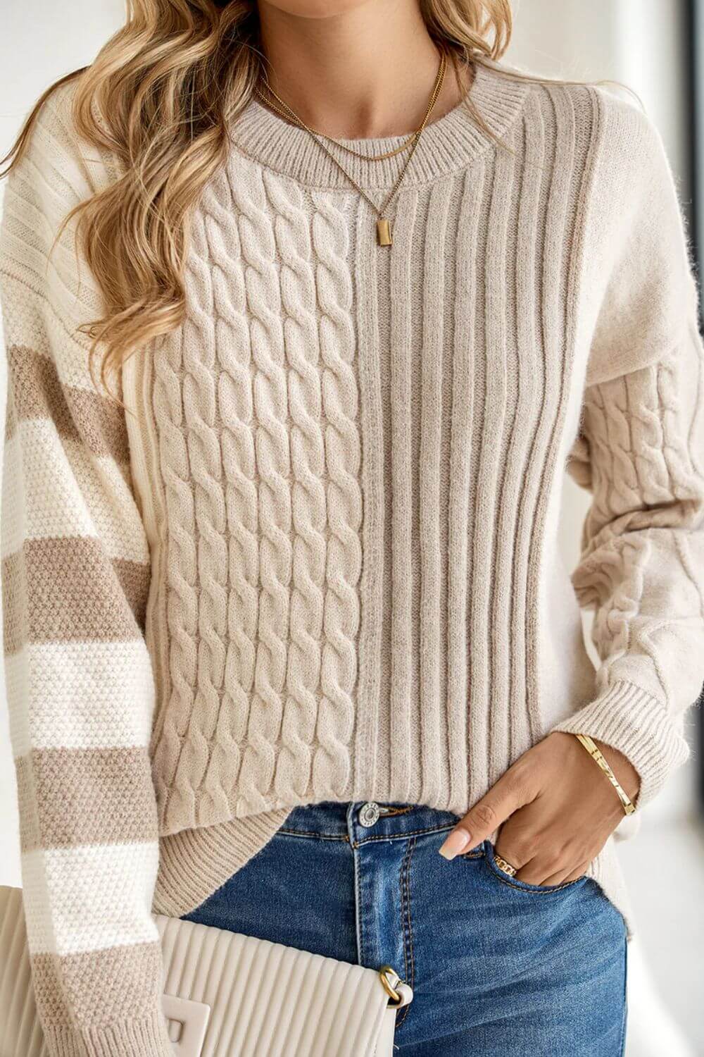 Woman wearing Bella Road cable-knit color block round neck sweater in tan, stylish and cozy fashion for cool days.