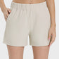 Millennia elastic waist active shorts in light beige with pockets and moderate stretch for ultimate comfort.