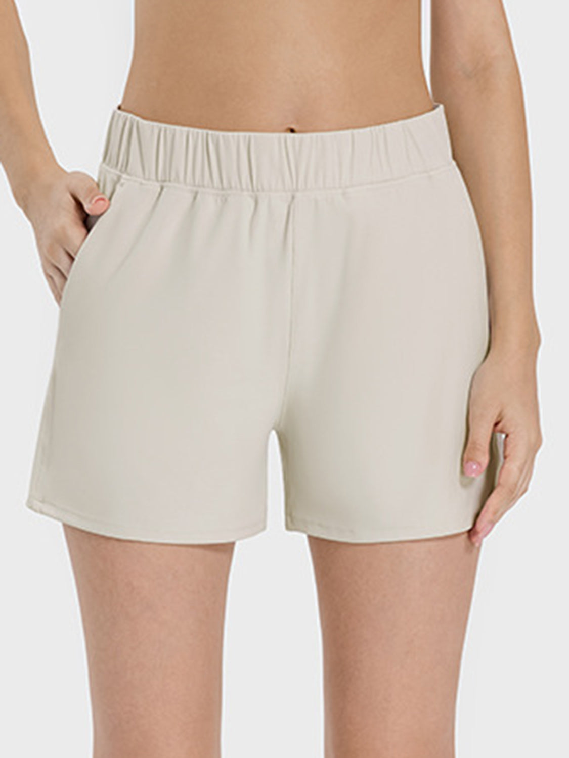 Millennia elastic waist active shorts in light beige with pockets and moderate stretch for ultimate comfort.