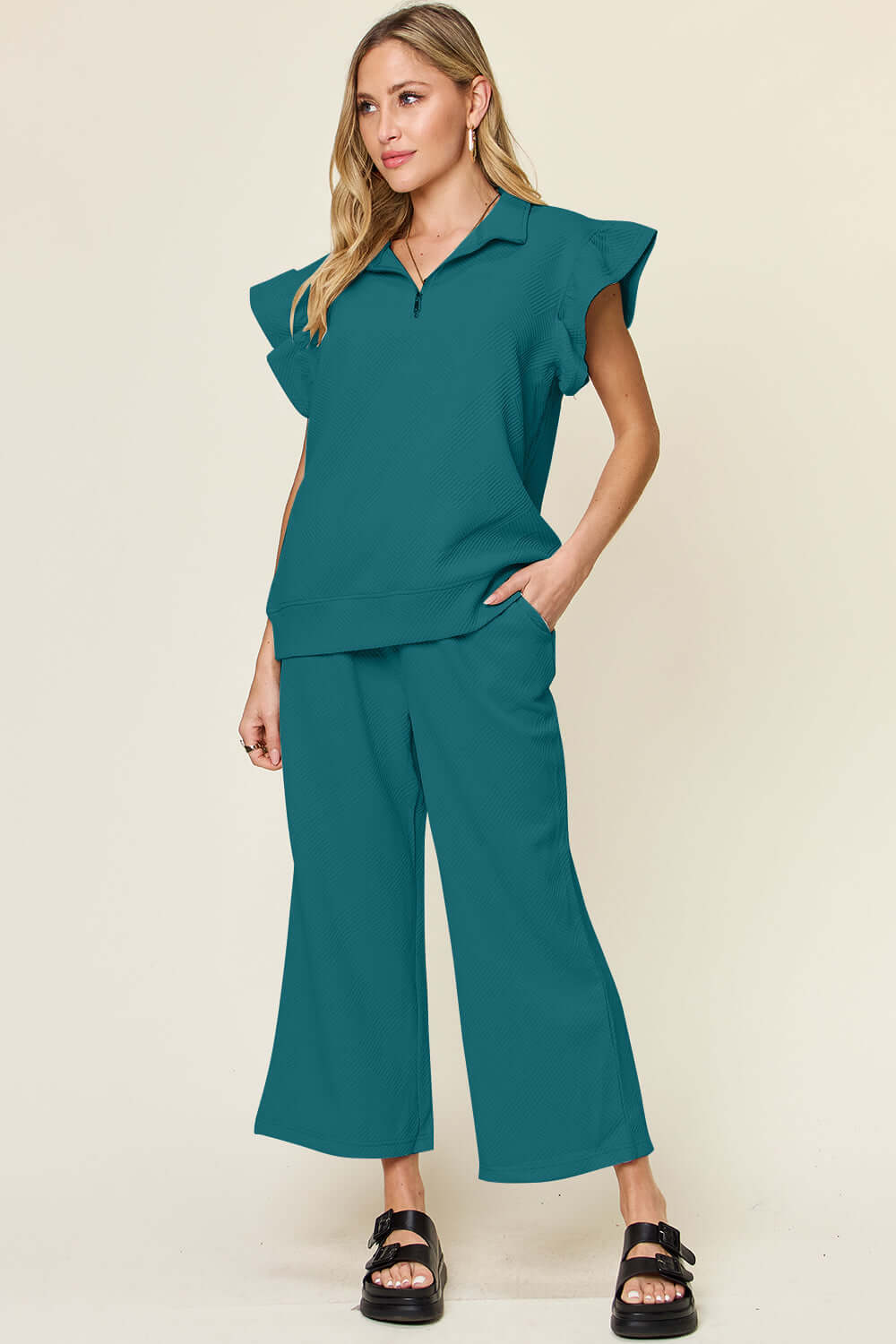 Woman wearing a teal Texture Ruffle Short Sleeve Top and Drawstring Wide Leg Pants Set with pockets.