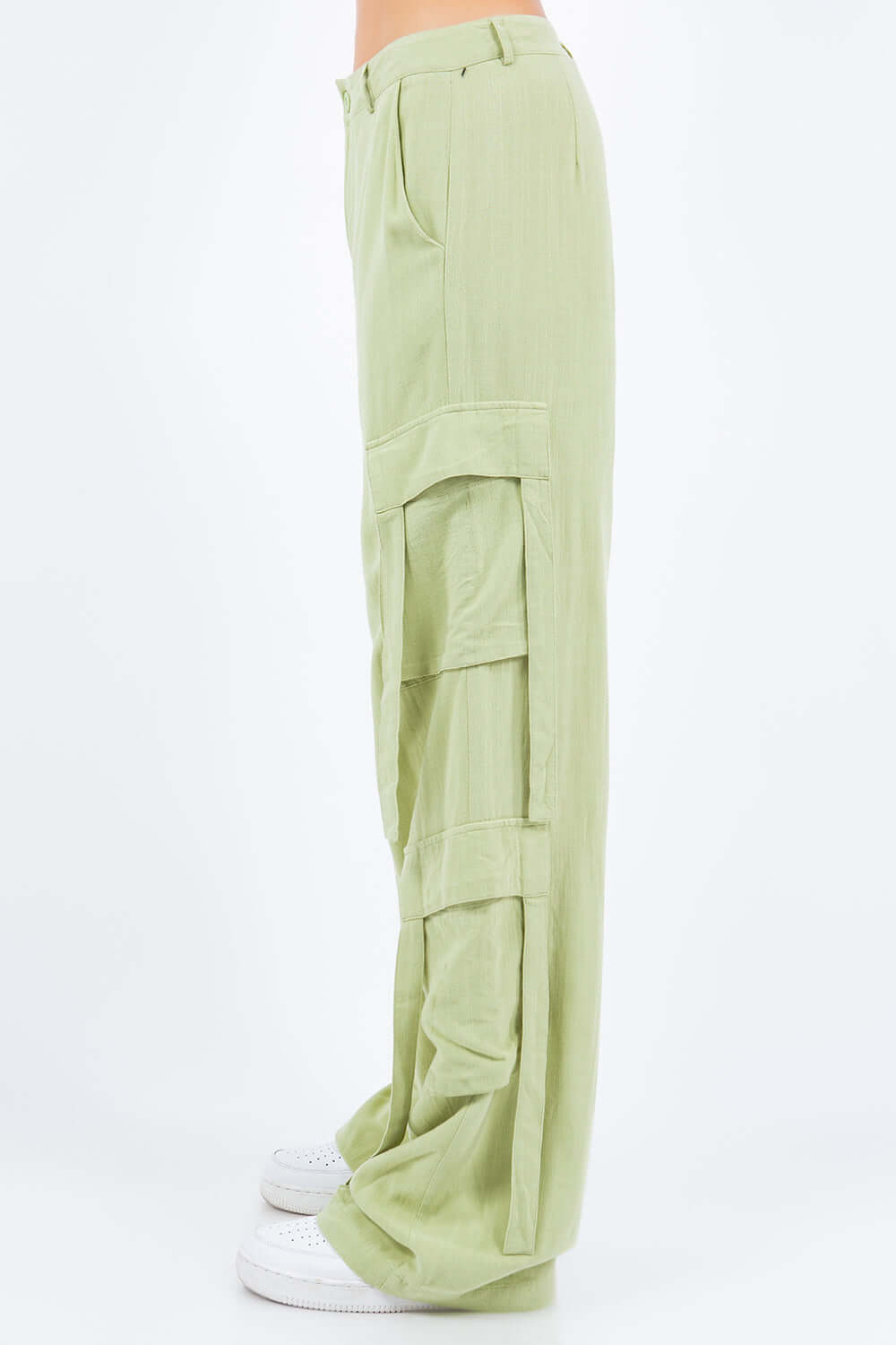 Side view of green linen wide leg cargo pants with relaxed fit and utility pockets