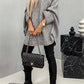 "Model wearing a cozy Bella Road batwing sleeve sweater with black pants and boots, accessorized with a quilted handbag"